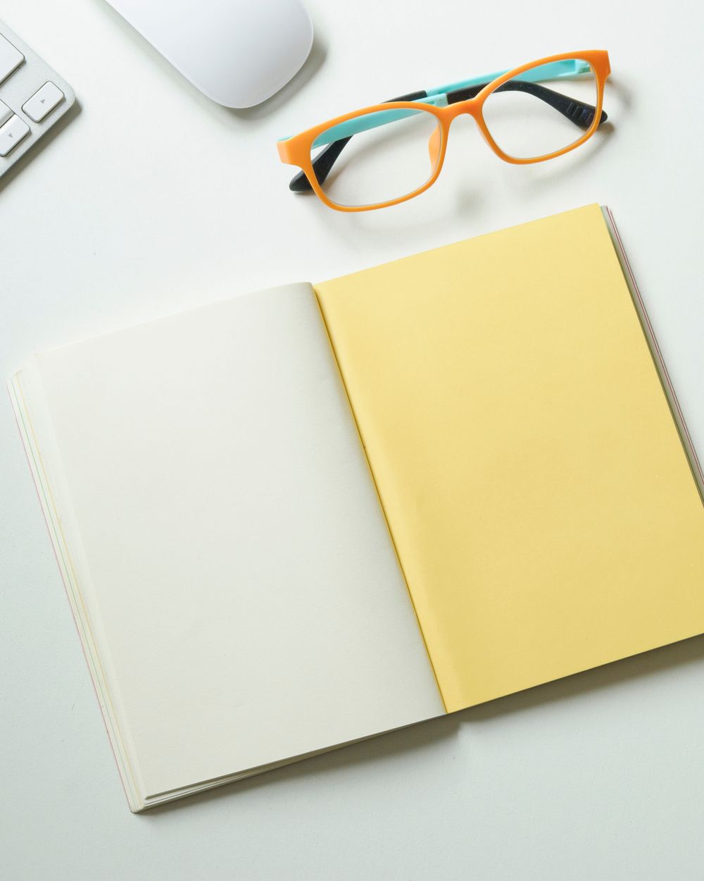 Óculos e caderno sobre uma mesa durante o briefing